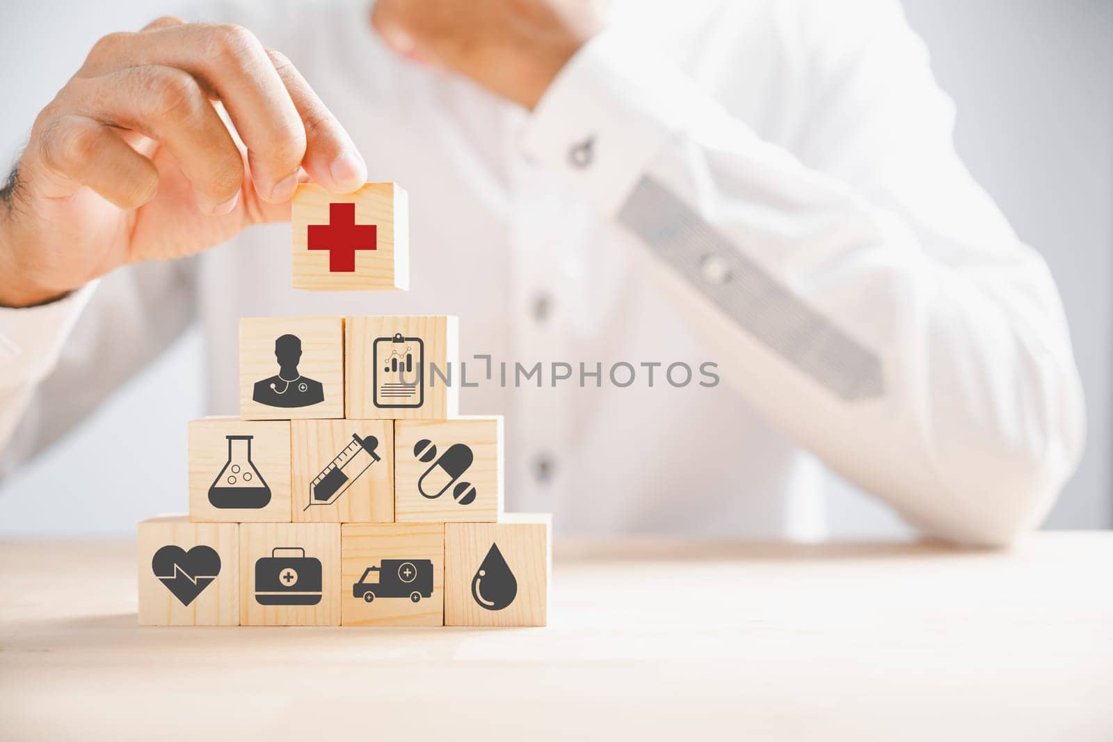 Wooden block with healthcare and medical icons held by hand. Illustrating safety, health, and family care, symbolizing pharmacy, heart well-being, and happiness. health care concept