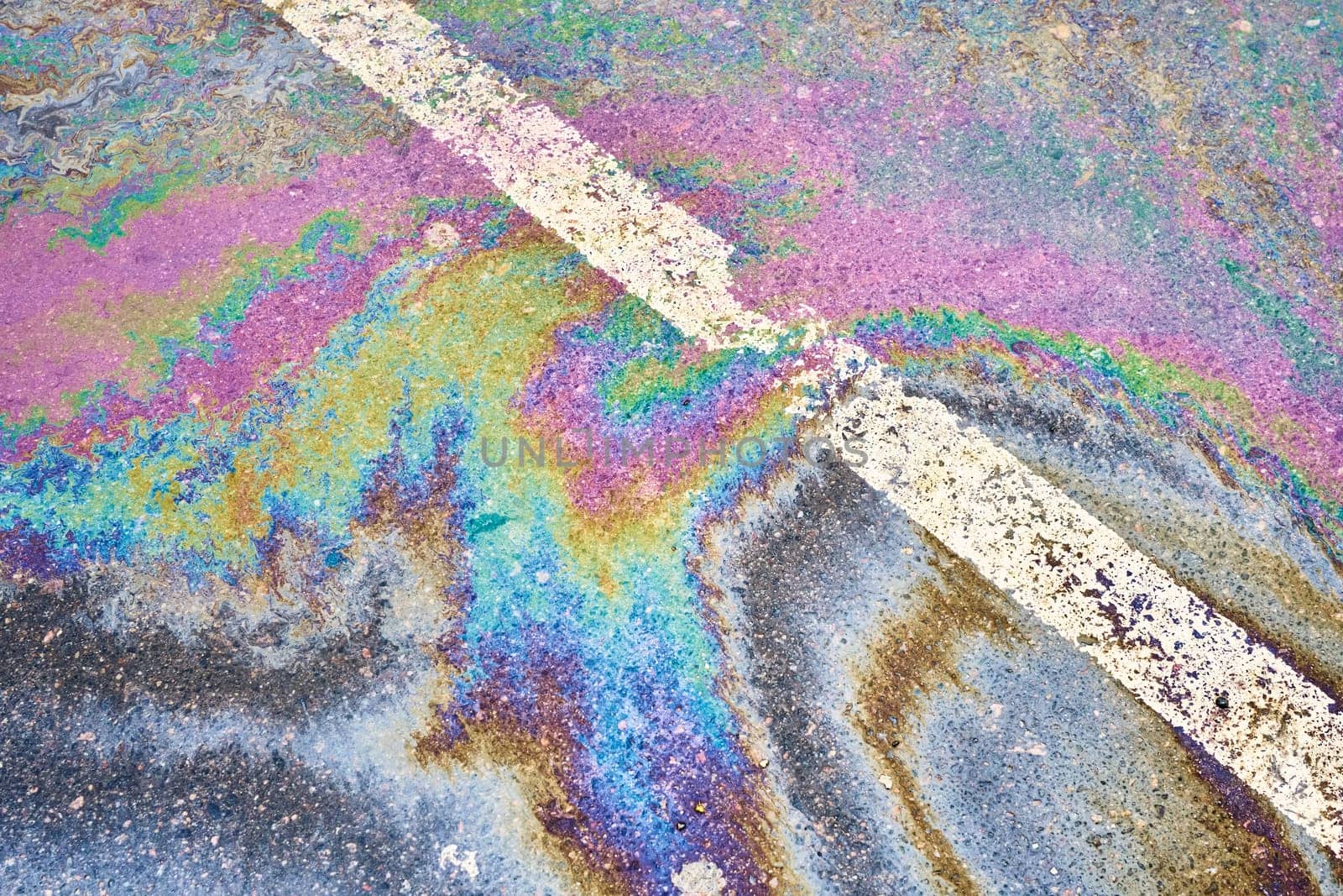 Oil discharge on rain-soaked pavement, parking lot with dividing lines, accentuating the environmental difficulties related to water pollution by AliaksandrFilimonau