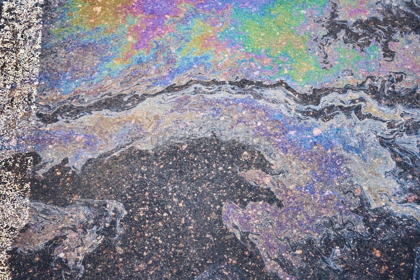 A car's oil and gas stains mark the surface of the parking asphalt by AliaksandrFilimonau