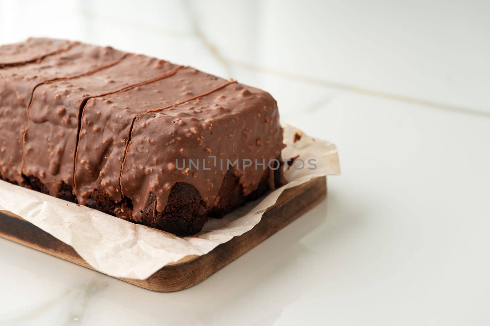 Fresh homemade chocolate sponge cake on wooden board close up