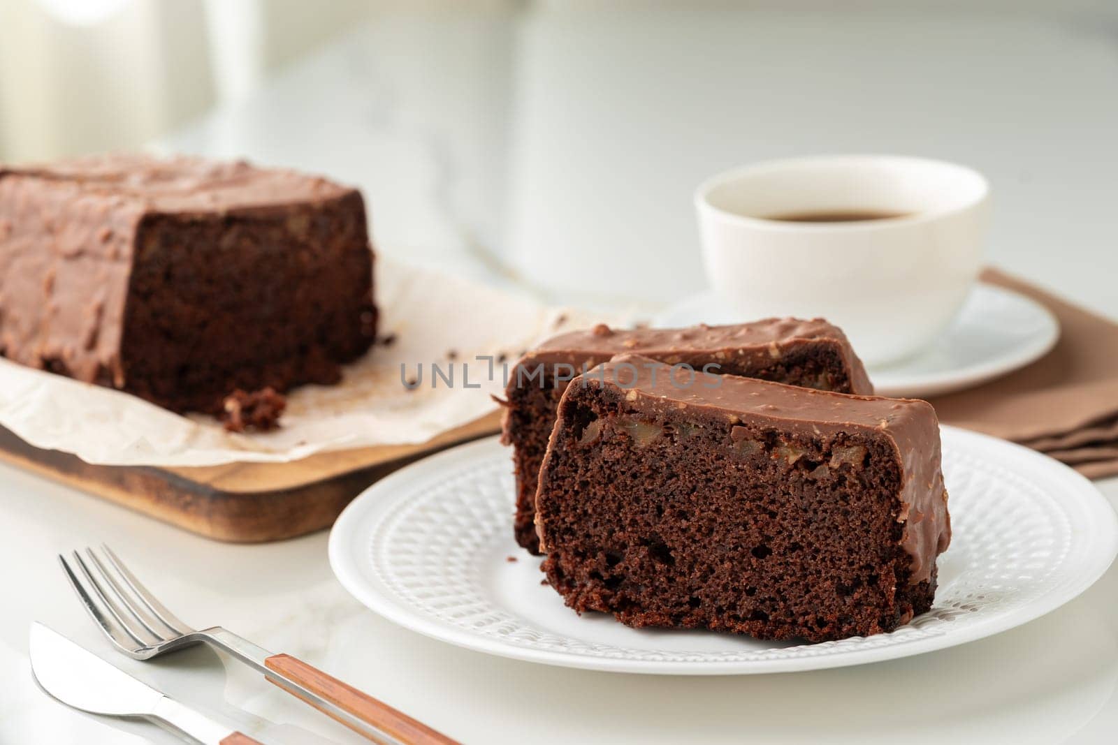 Fresh homemade chocolate sponge cake on wooden board close up