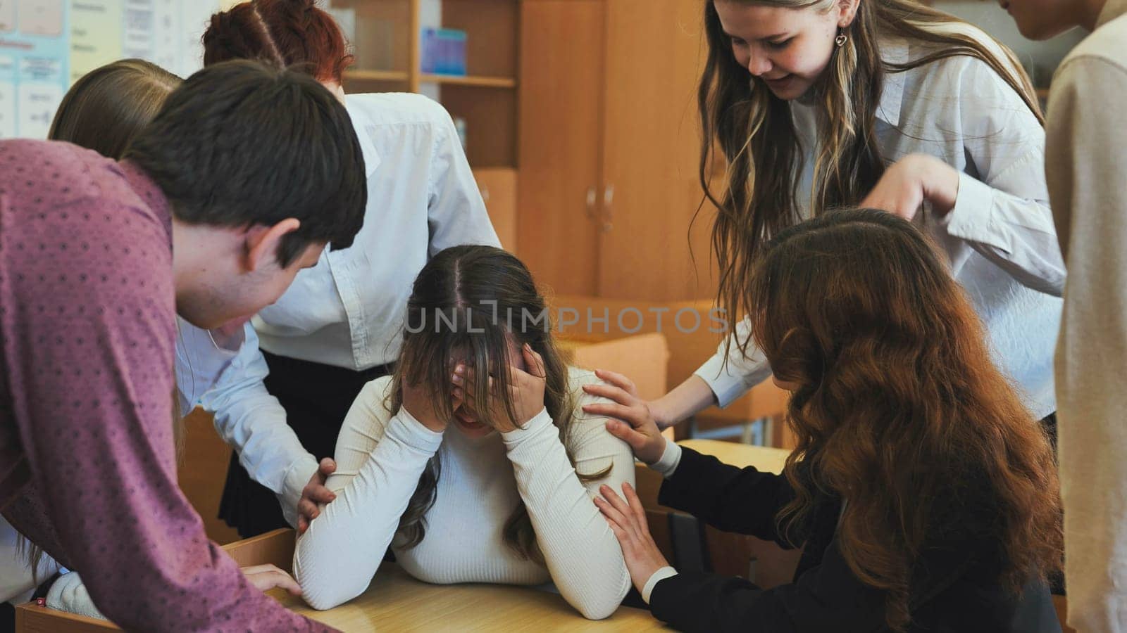 A high school girl cries and her friends comfort her. by DovidPro