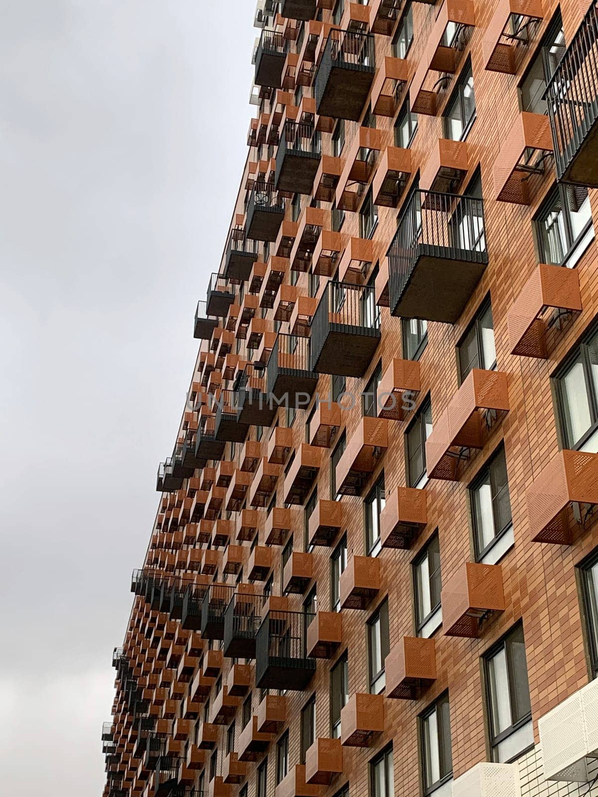 Residential complex in Moscow. New buildings in Moscow, high-rise bright creative house and against the sky. There are many apartments with Windows.