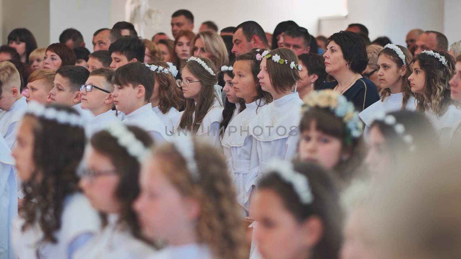 Lida, Belarus - May 31, 2022: Children in a Catholic church during their first communion. by DovidPro