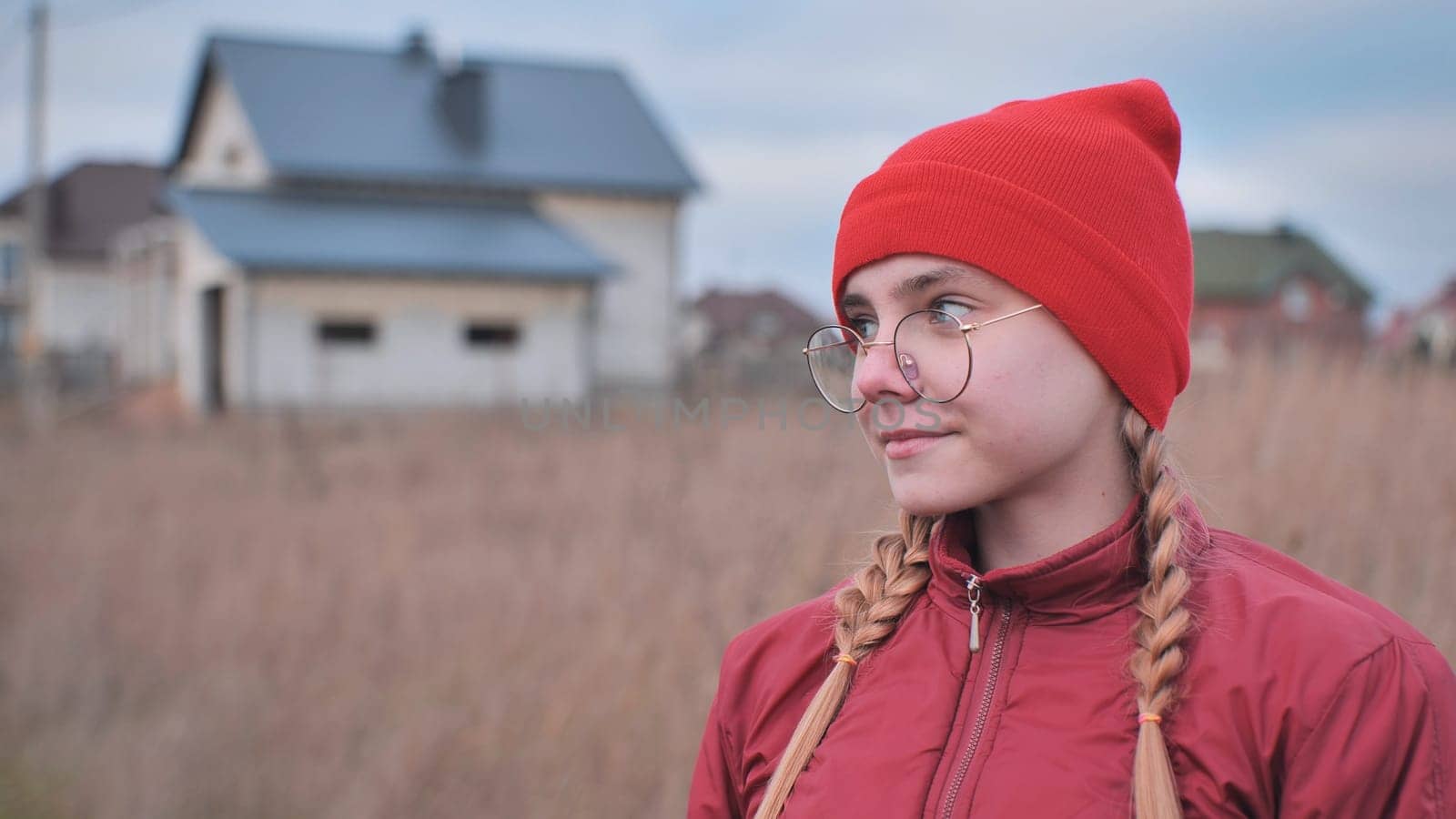 Portrait of a teenage girl in glasses wearing red clothes outside in the fall. by DovidPro