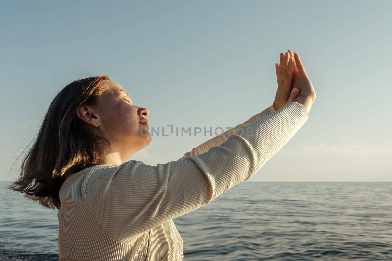A woman stands confidently on the deck of a boat, overlooking the vast ocean.