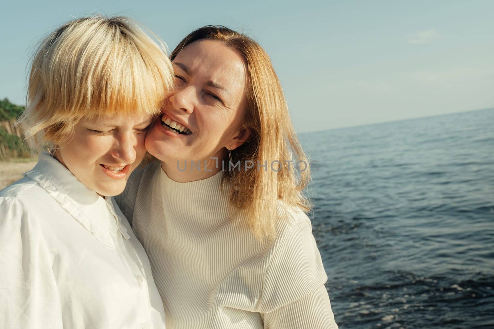 Mom hugs her daughter on the beach by the sea. by Sd28DimoN_1976