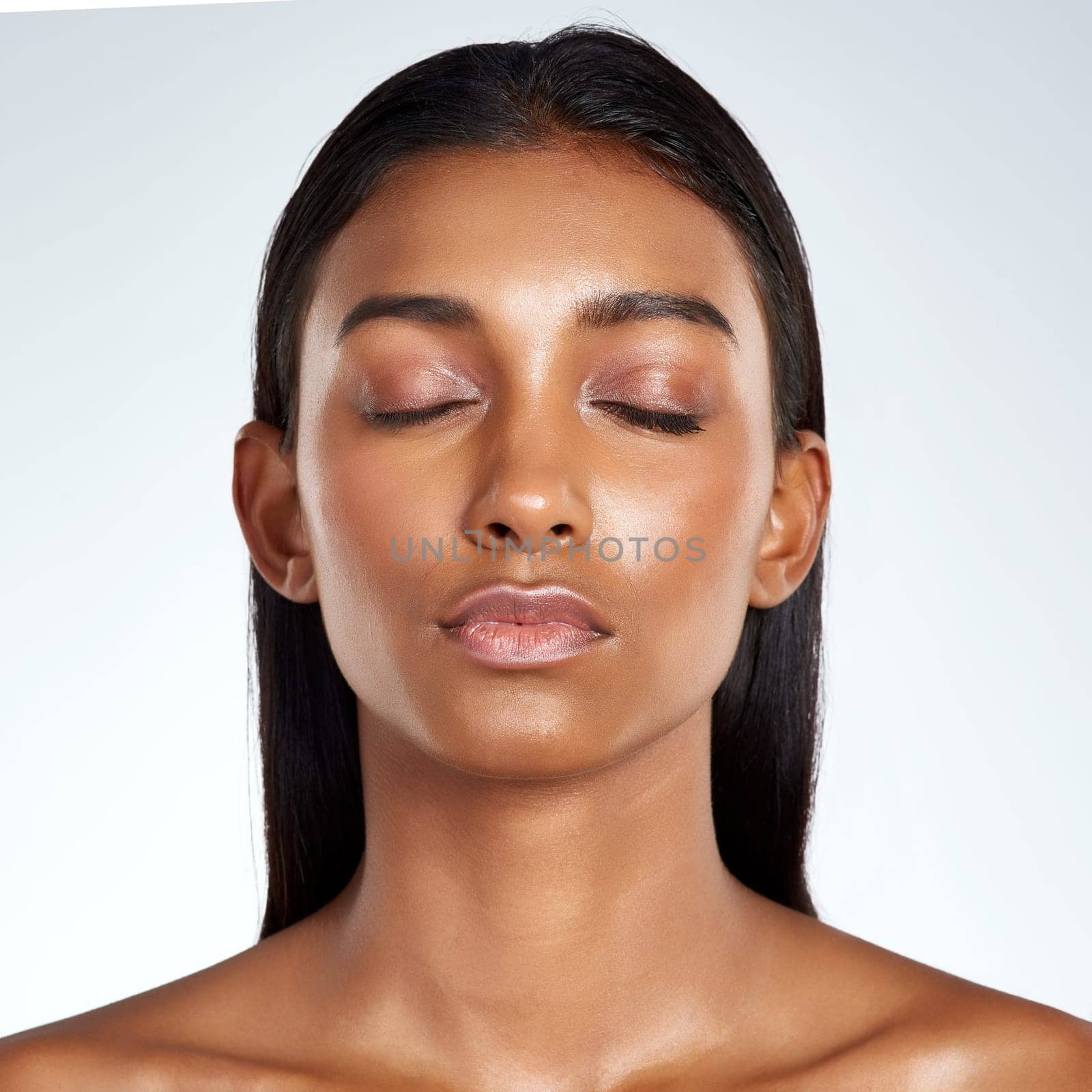 Studio, face and beauty with Indian woman, calm and cosmetic or makeup. Cosmetology, beautician and confidence with glow female model, salon treatment and skincare for wellness on white background.