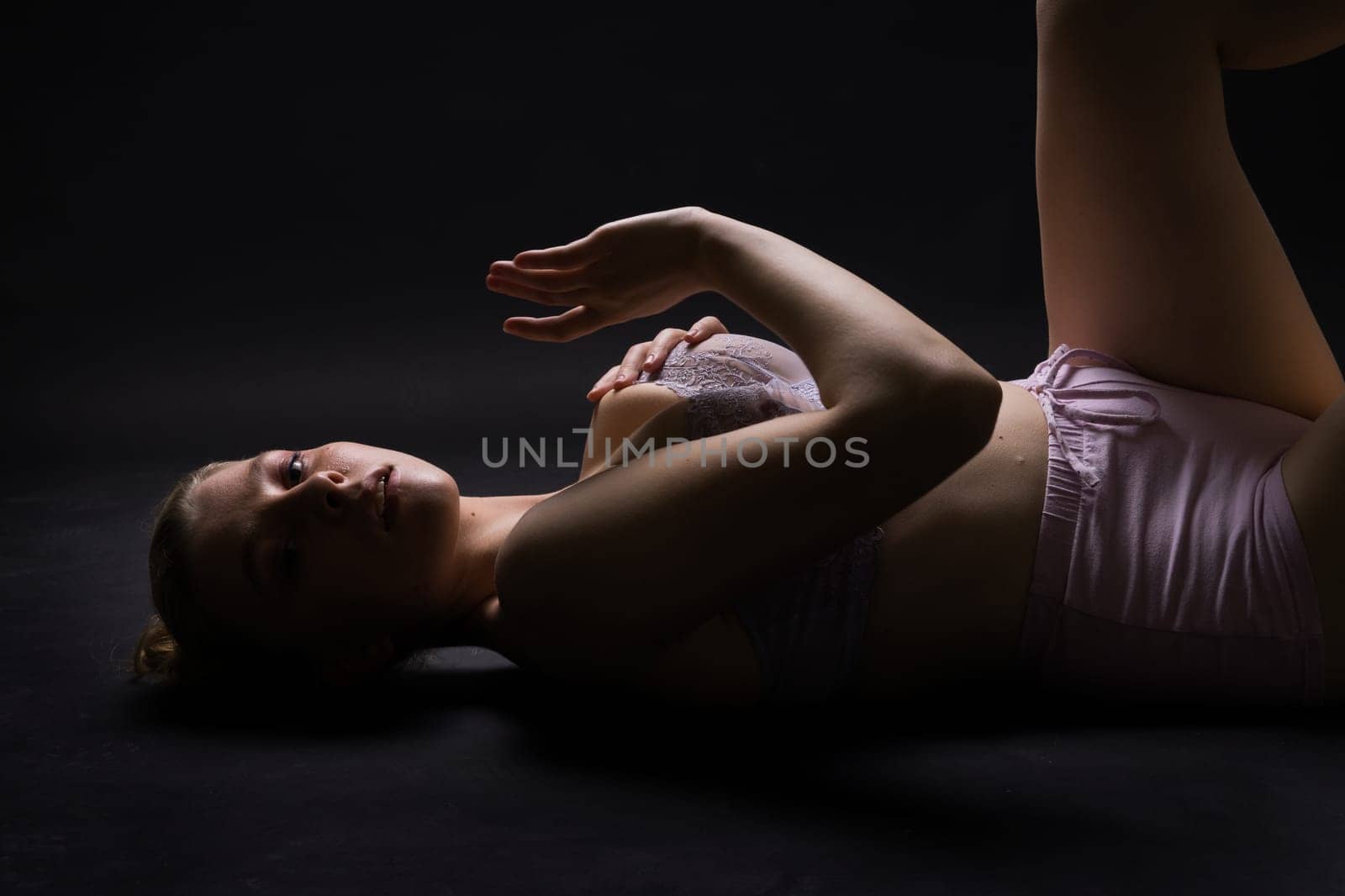 Seductive attractive blonde woman posing in fashionable lingerie in studio by Zelenin