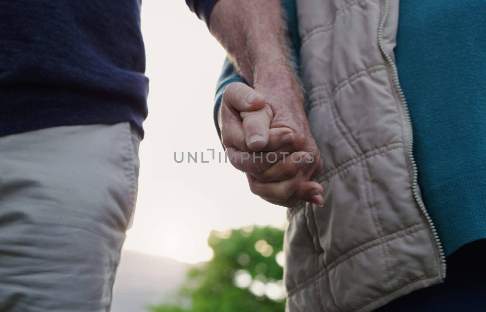 Couple, people and holding hands in outdoor for walk, together and support in London. Relationship, date and bonding for romance with sunset for care, relax and happiness as soulmate for love.