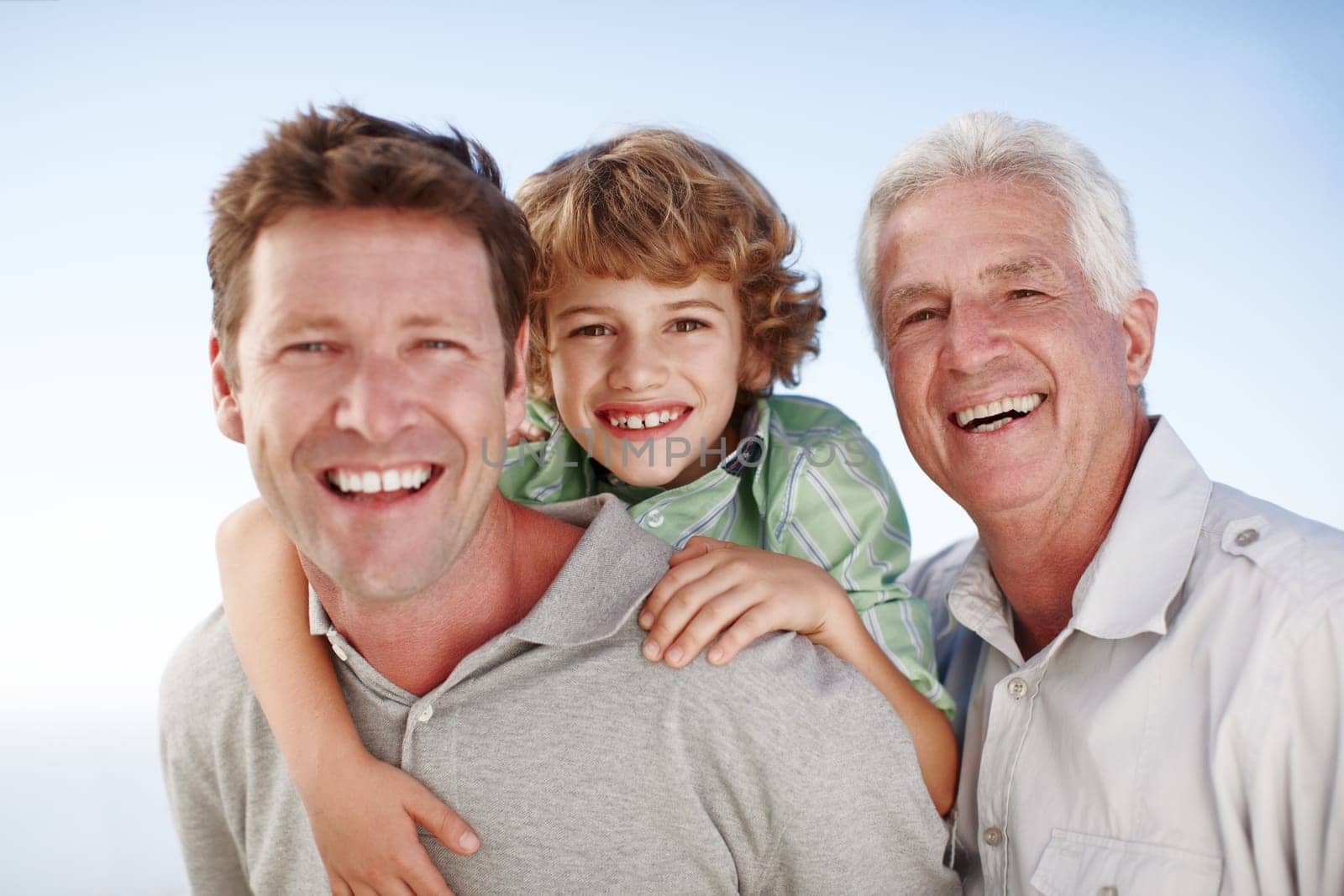 Portrait of grandfather, dad and child by nature and blue sky for bonding, relationship or relax together. Family, fun and grandpa, father and young boy on shoulders for holiday, vacation and weekend.