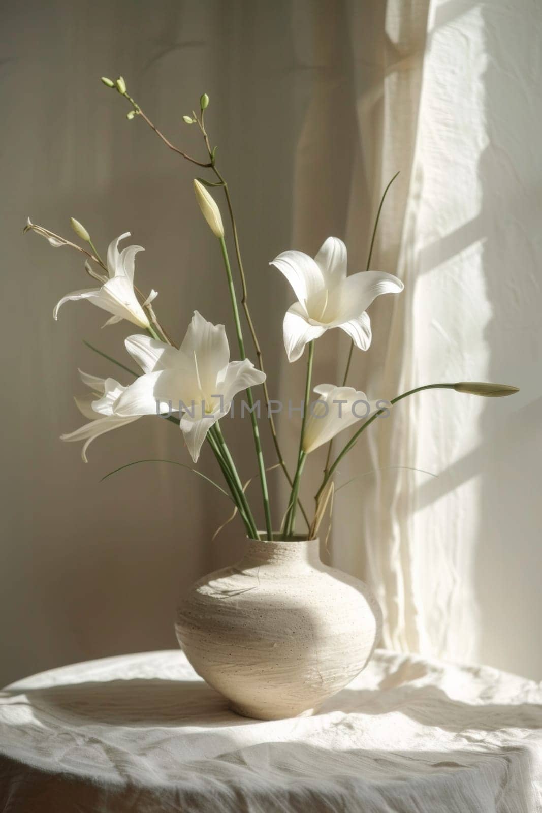A vase with white flowers on a table in front of window