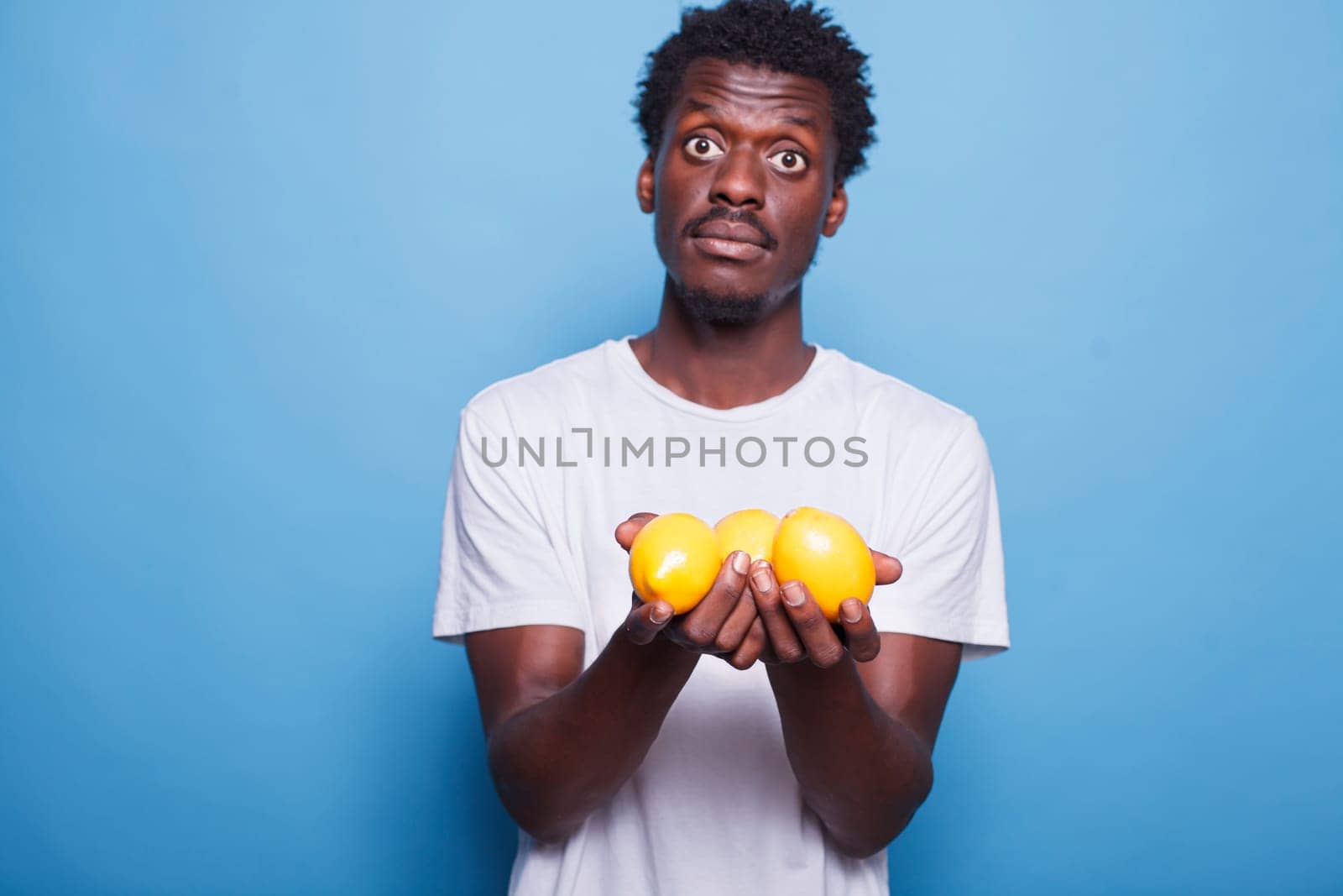 African american man carrying lemons by DCStudio