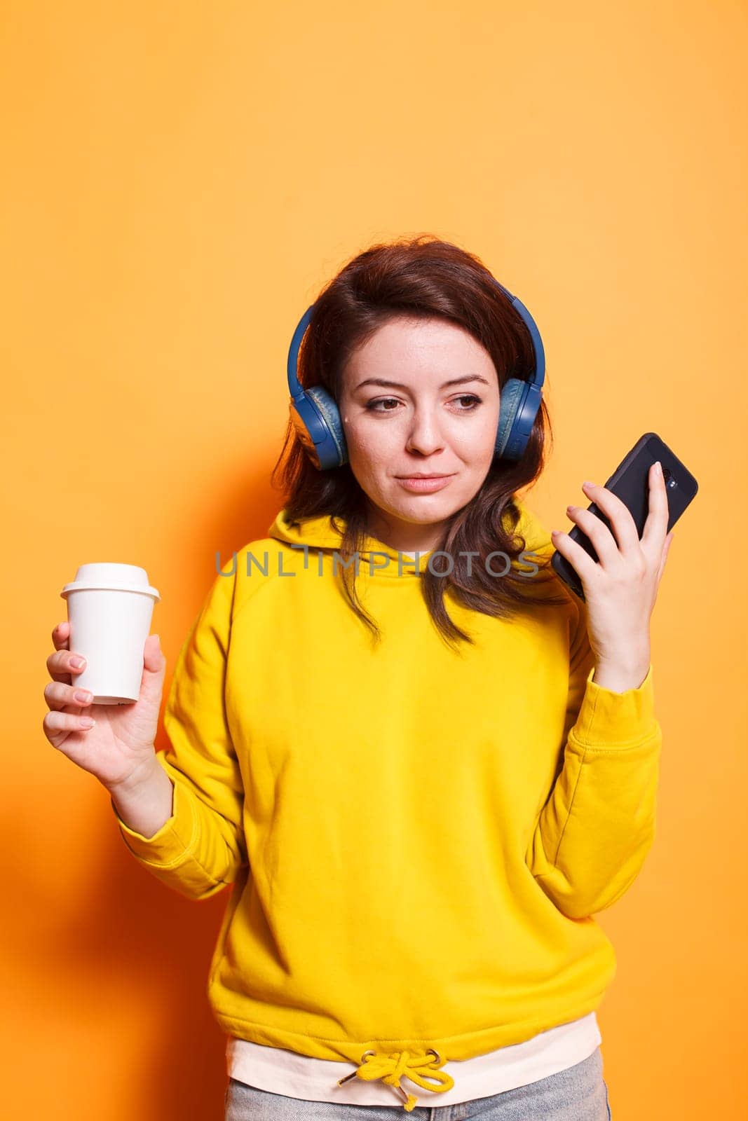 Female adult grasps phone and coffee cup by DCStudio