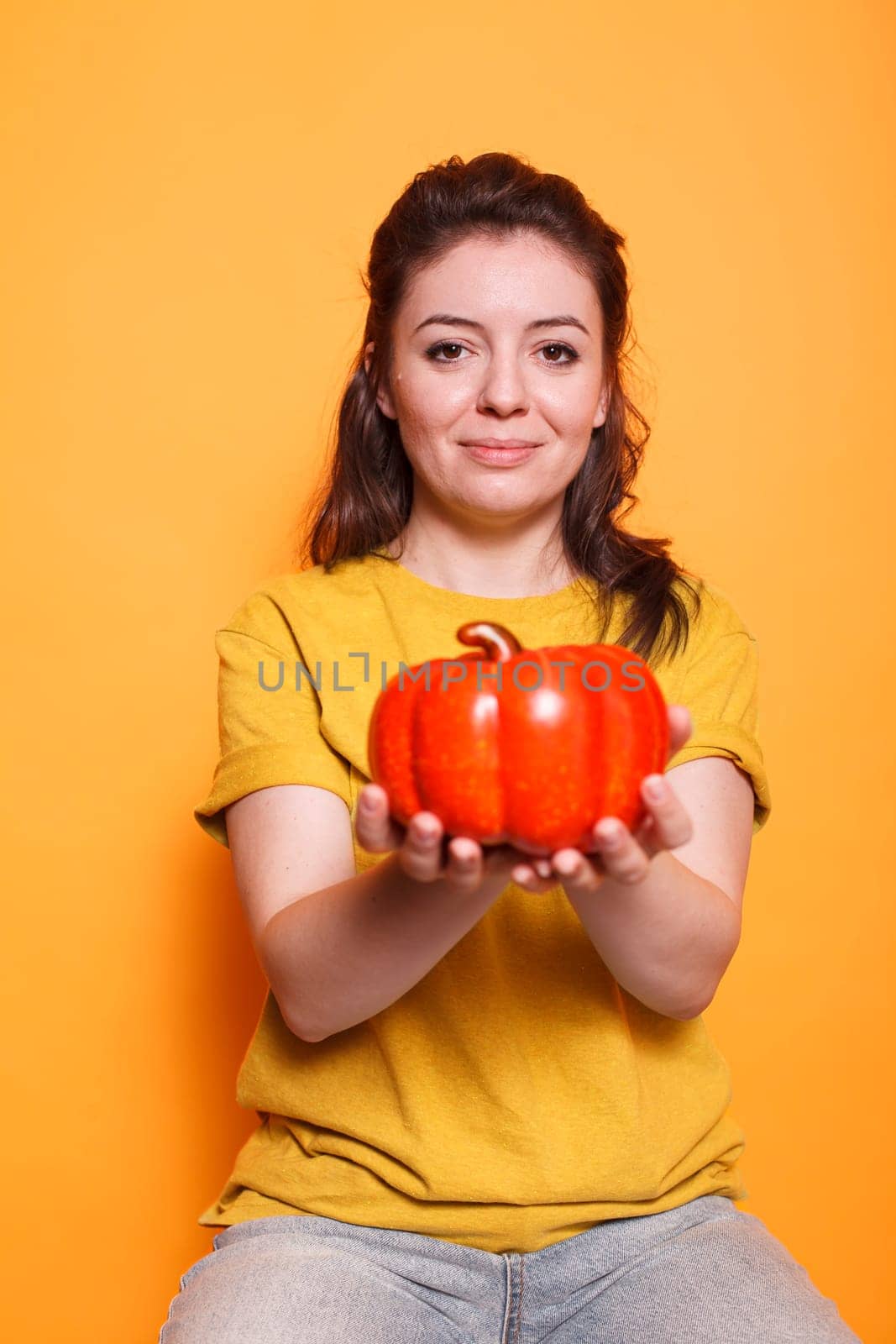 Young lady gripping a bell pepper by DCStudio