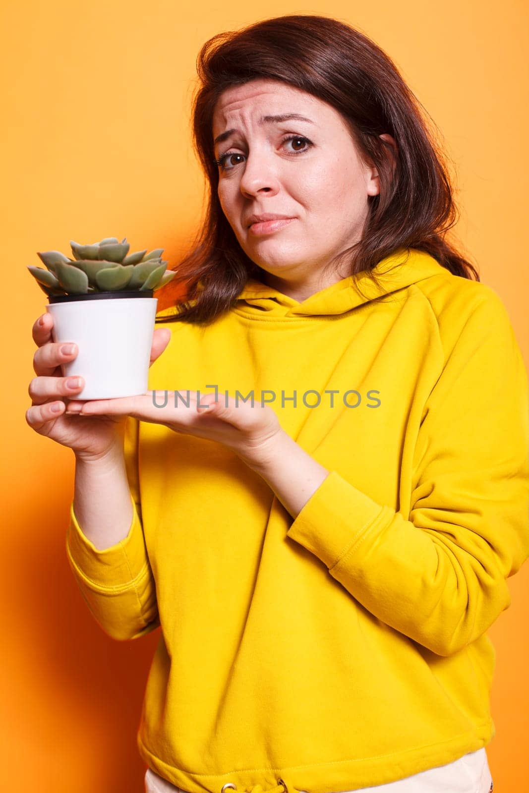Female plant lover holding flowerpot by DCStudio