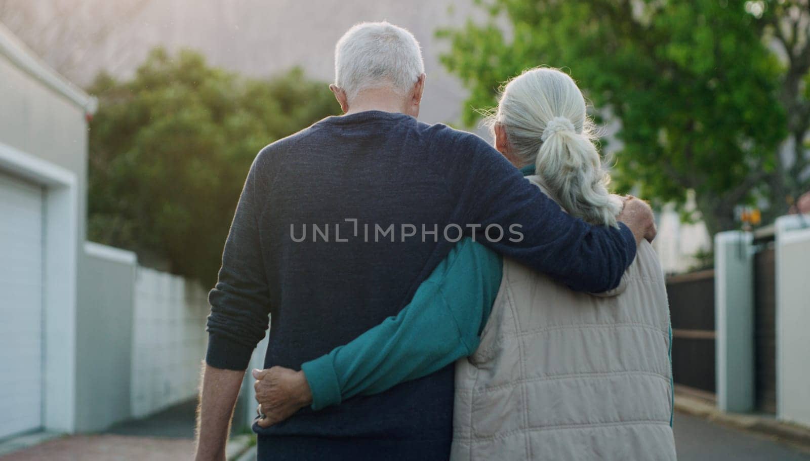 Senior couple, walk and hug in city, road and driveway of house for love, peace and support outdoor. Elderly people, freedom and retirement together in nature, environment or urban with back view by YuriArcurs