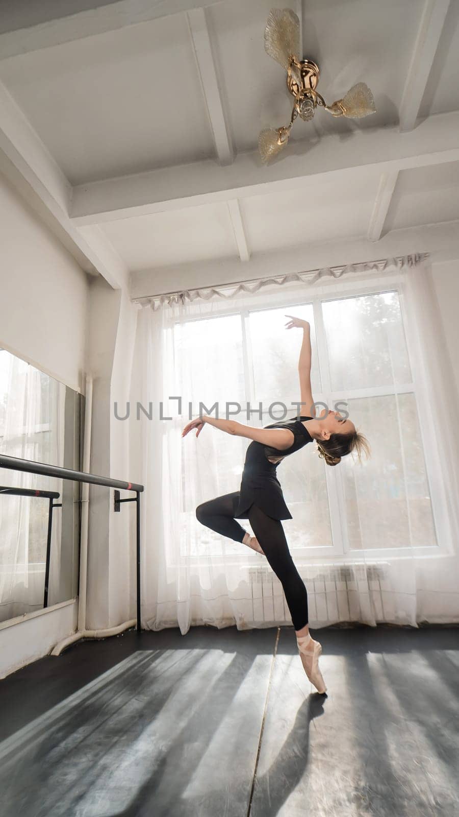 A beautiful Asian woman is dancing at the barre. Ballet dancer