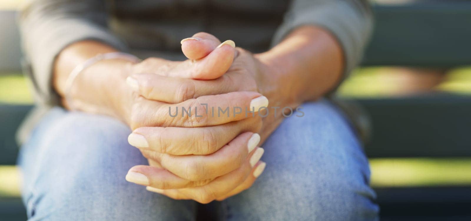 Hands, nervous and worry with person thinking outdoor on bench for anxiety, depression or stress. Mental health, prayer and wellness with adult closeup in garden or park for fail, mistake and regret by YuriArcurs