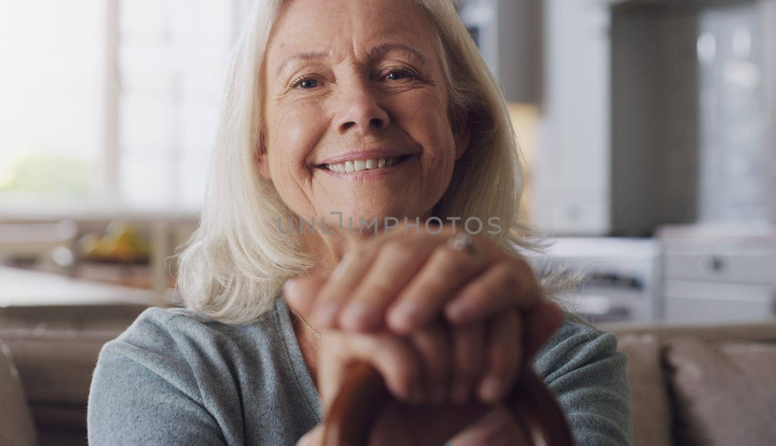 Smile, walking stick and portrait of senior woman on sofa in living room at retirement home. Happy, confident and elderly female person with a disability for hands on cane relaxing in lounge at house.