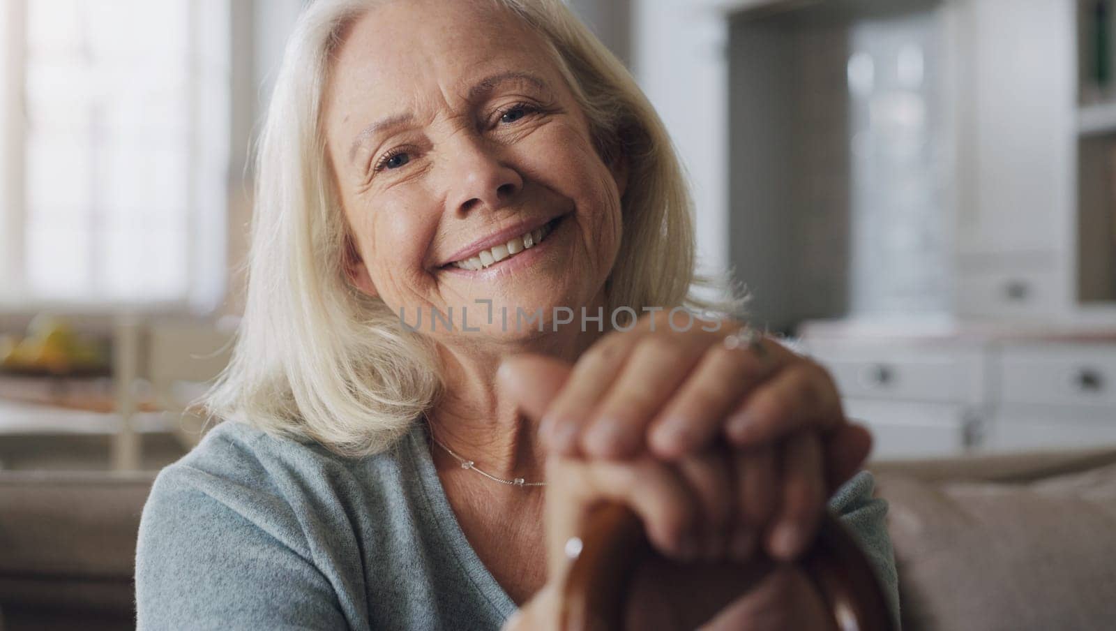 Happy, walking stick and portrait of senior woman on sofa in living room at retirement home. Smile, confident and elderly female person with a disability for hands on cane relaxing in lounge at house.