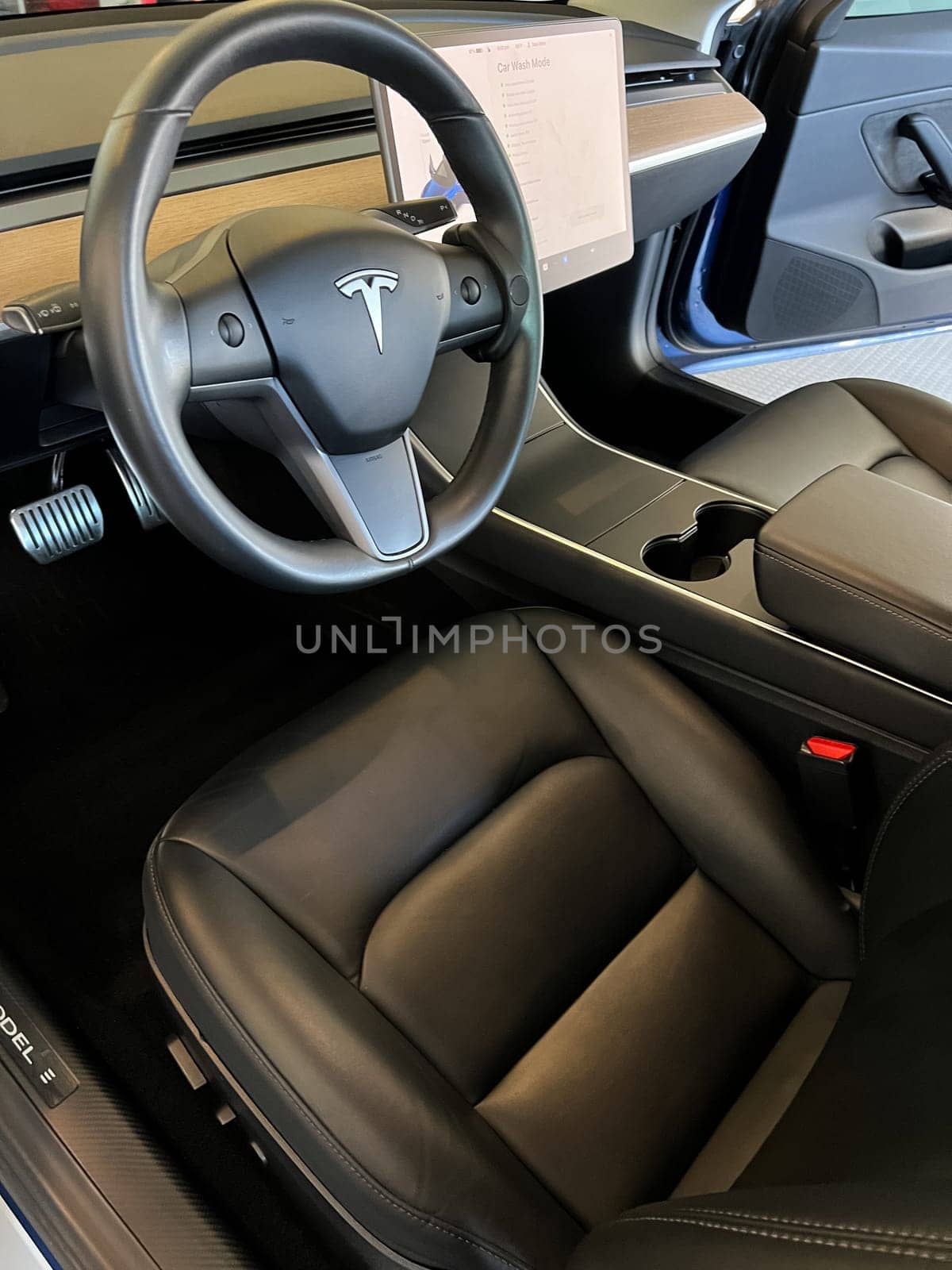 Castle Rock, Colorado, USA-March 14, 2024-The interior of a Tesla Model 3, featuring its premium black seats and modern dashboard, receives a meticulous cleaning in the garage of a private residence.