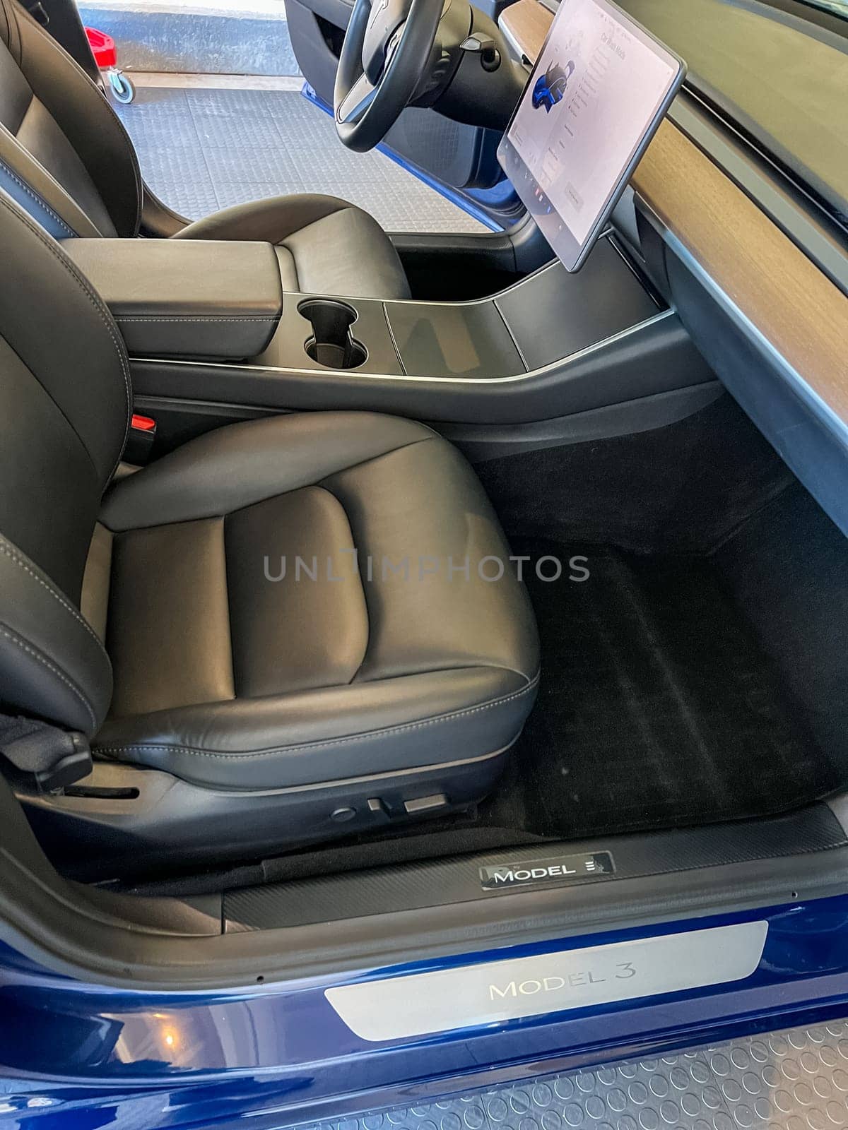 Castle Rock, Colorado, USA-March 14, 2024-The interior of a Tesla Model 3, featuring its premium black seats and modern dashboard, receives a meticulous cleaning in the garage of a private residence.