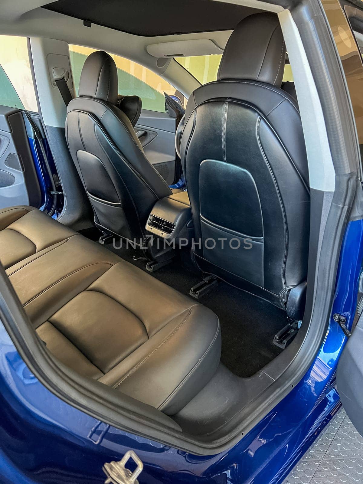 Castle Rock, Colorado, USA-March 14, 2024-The interior of a Tesla Model 3, featuring its premium black seats and modern dashboard, receives a meticulous cleaning in the garage of a private residence.