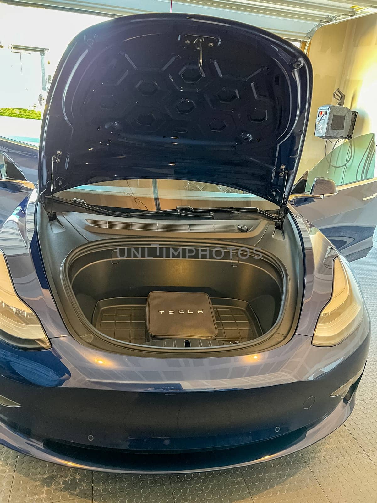 Castle Rock, Colorado, USA-March 14, 2024-The interior of a Tesla Model 3, featuring its premium black seats and modern dashboard, receives a meticulous cleaning in the garage of a private residence.