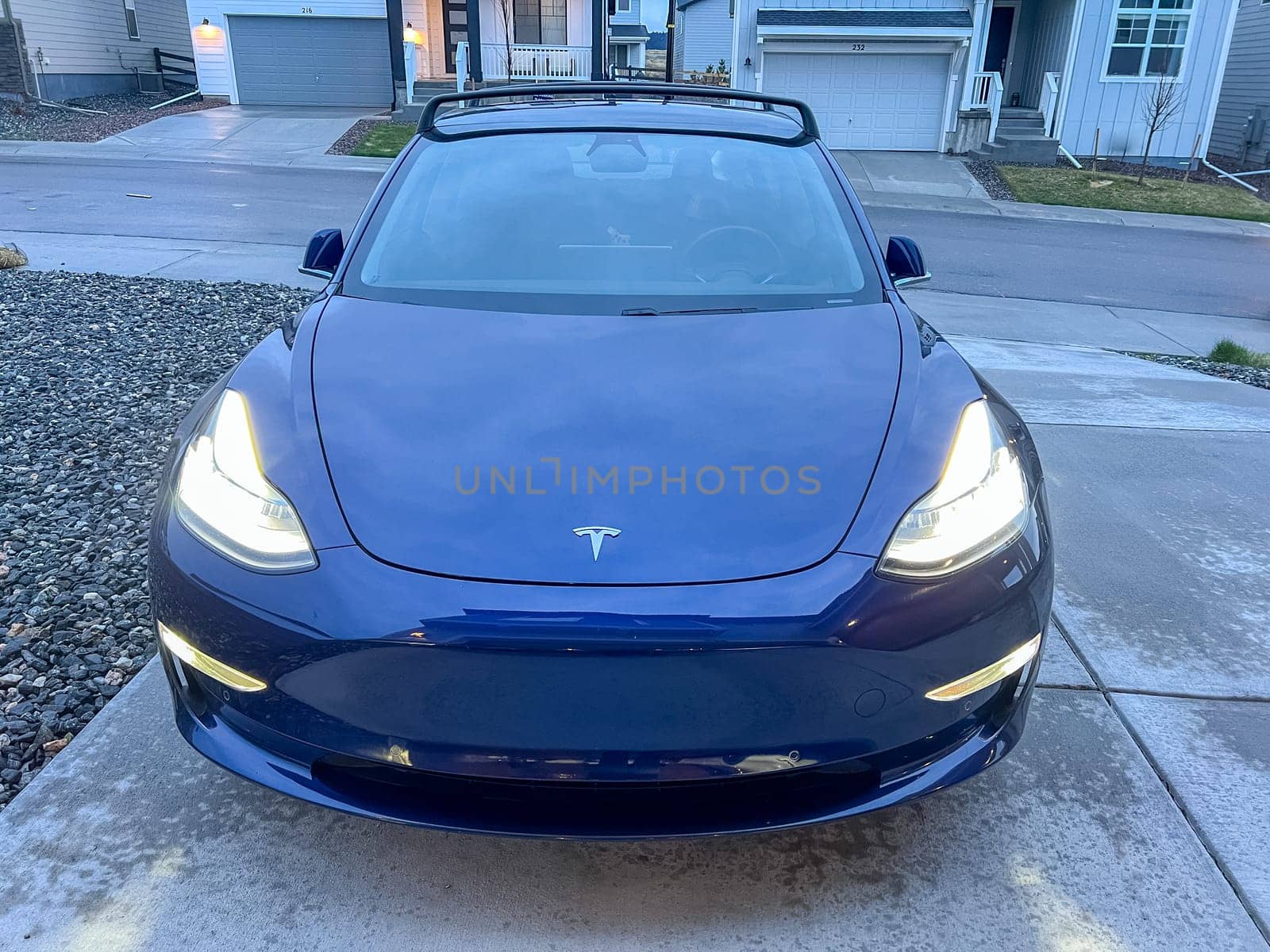 Castle Rock, Colorado, USA-March 14, 2024-A shiny blue Tesla Model 3 sits in the well-kept garage of a single-family house, its sleek design accentuated by the gentle care of a home car wash.