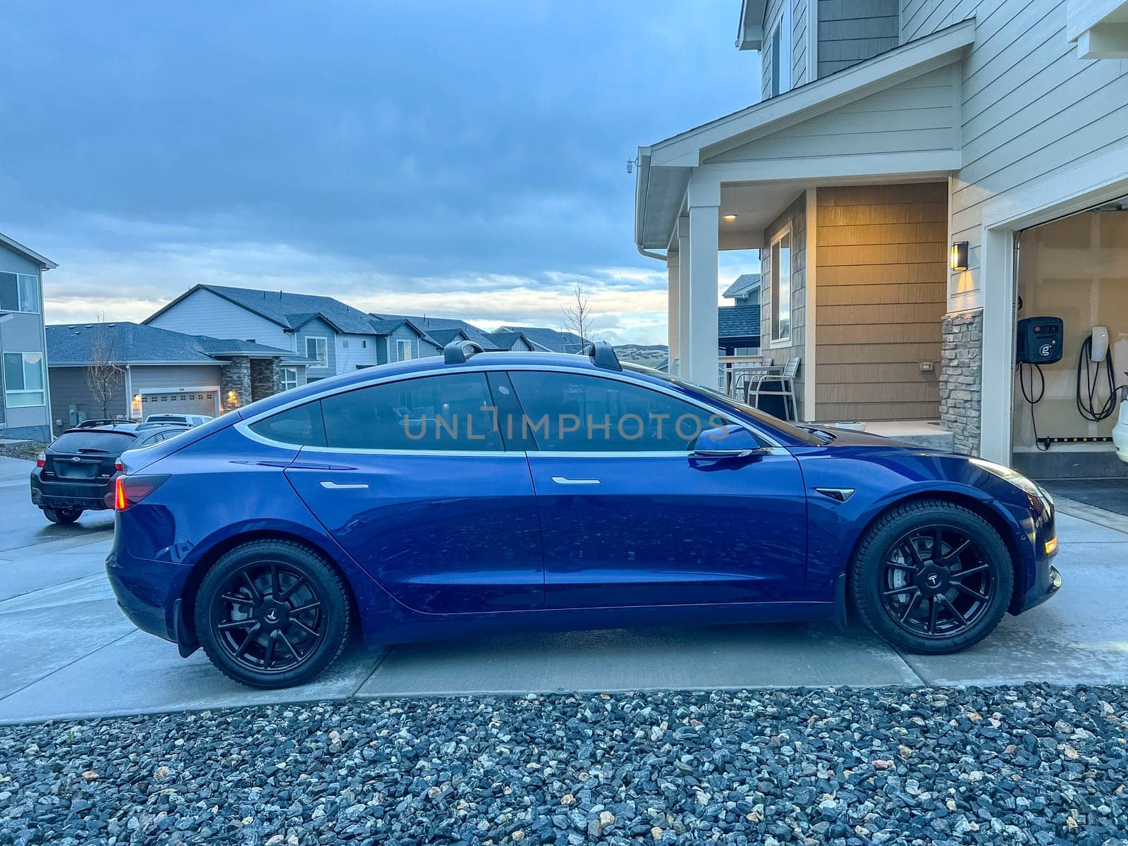 Tesla Model 3 Receiving a Wash in the Garage of a Suburban Home by arinahabich