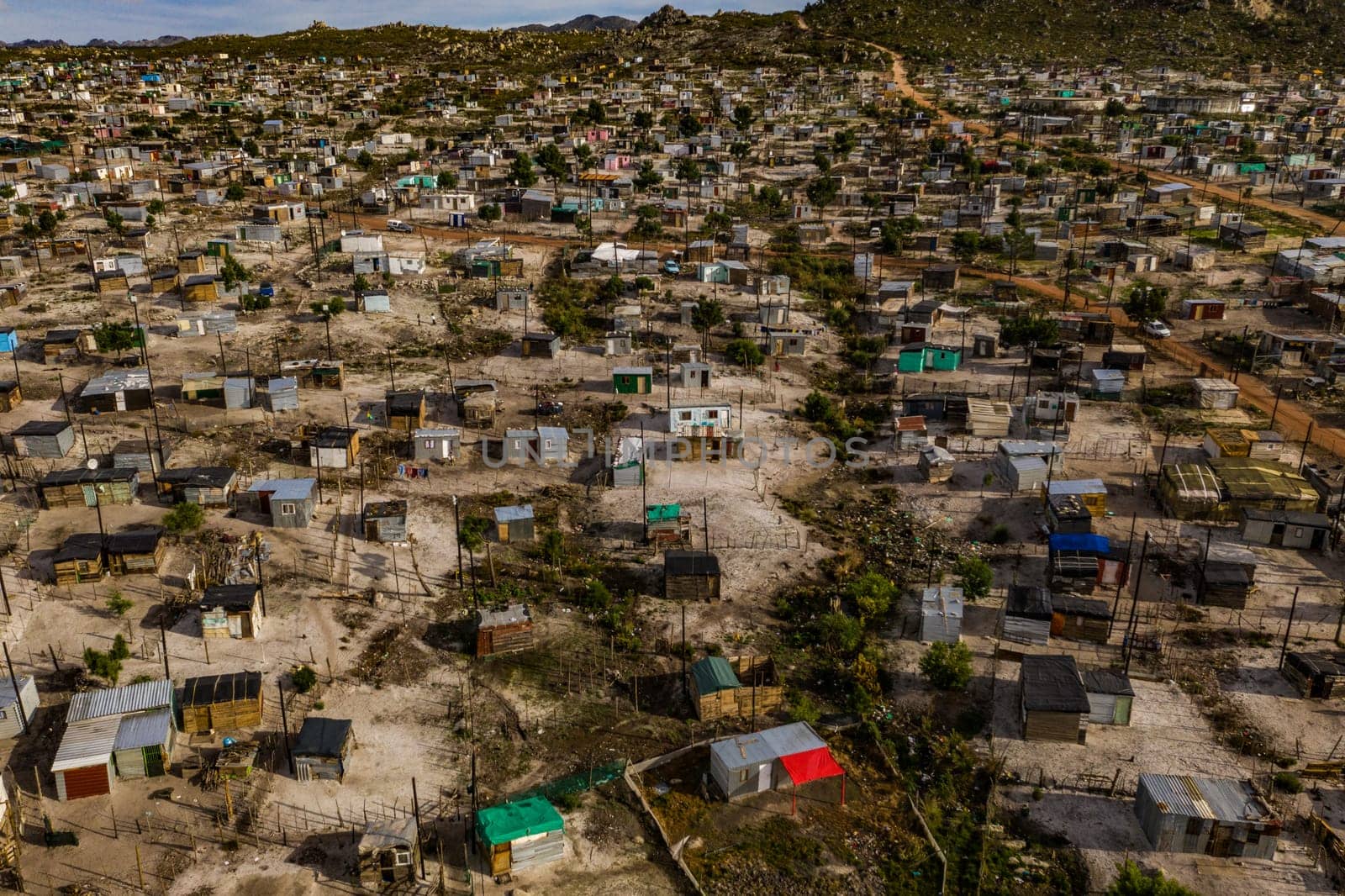 Rural, township and poverty with shacks, houses or informal settlement of land or squatter camps in South Africa. Aerial view of village, housing or poor infrastructure of town or developing country by YuriArcurs