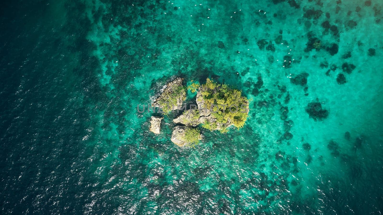 Drone, ocean or island and rock in water for summer adventure, travel location or holiday destination. Aerial view, beach or natural environment with tropical landscape or sea background in Indonesia.