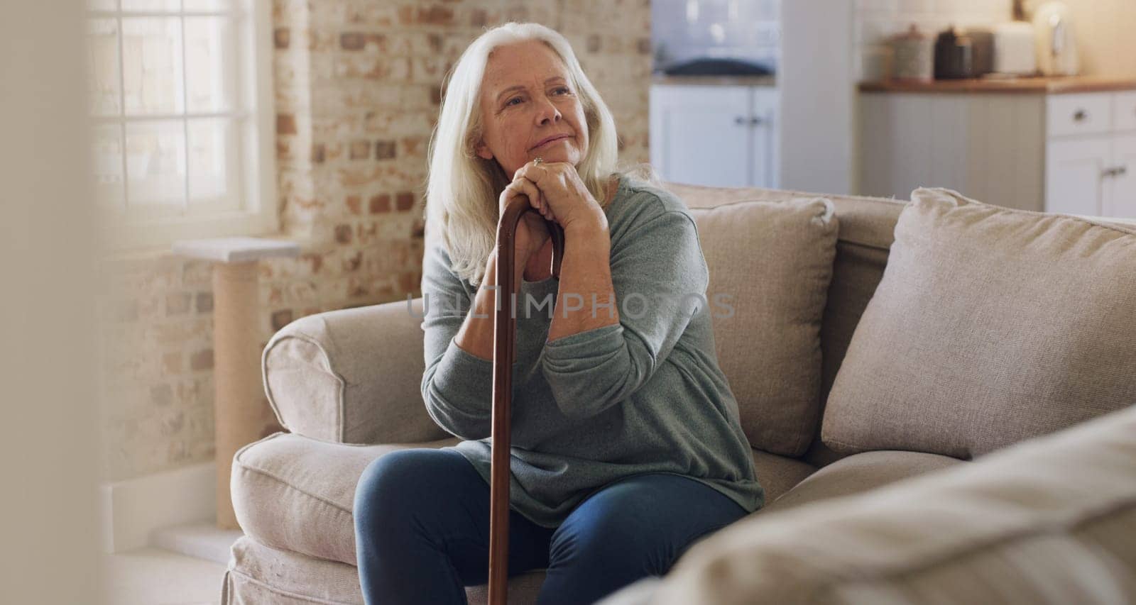 Senior woman, thinking and walking stick for balance in home, recovery and memory or relax on sofa. Retirement, wonder and person with disability on couch, arthritis and cane for assistance or help.