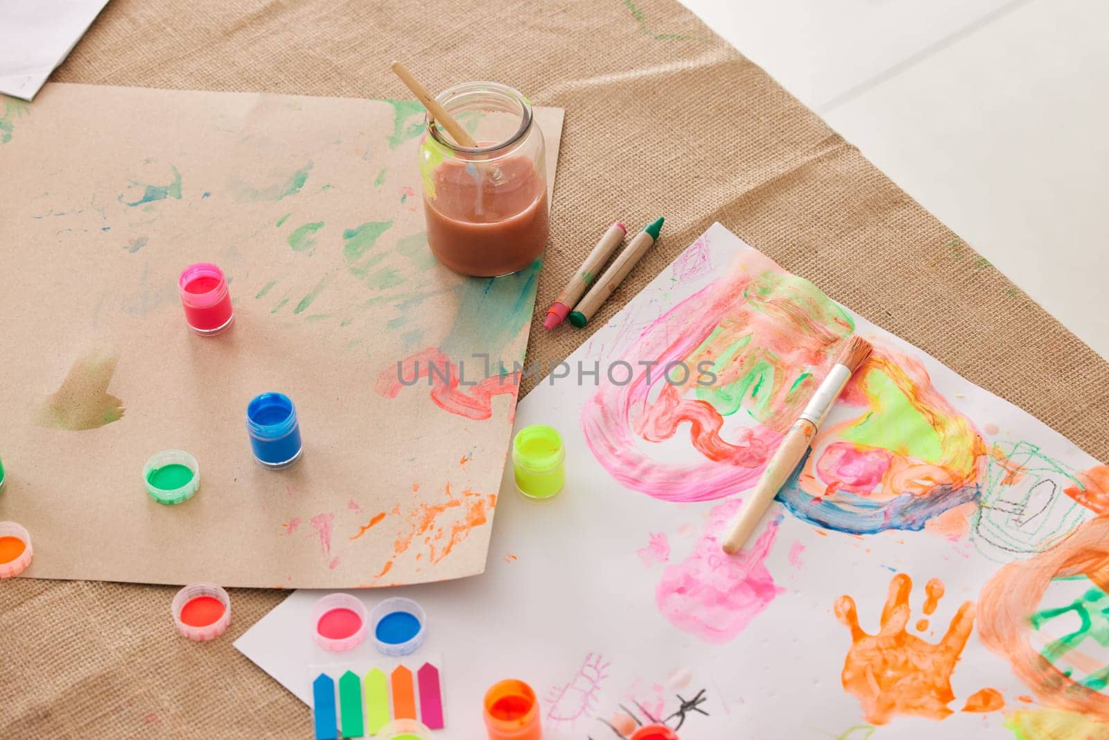 Paint, paper and art project in classroom, watercolor and brush with supplies for creativity. Education, learning and craft workspace, artwork and stationary for fun with a canvas in kindergarten.