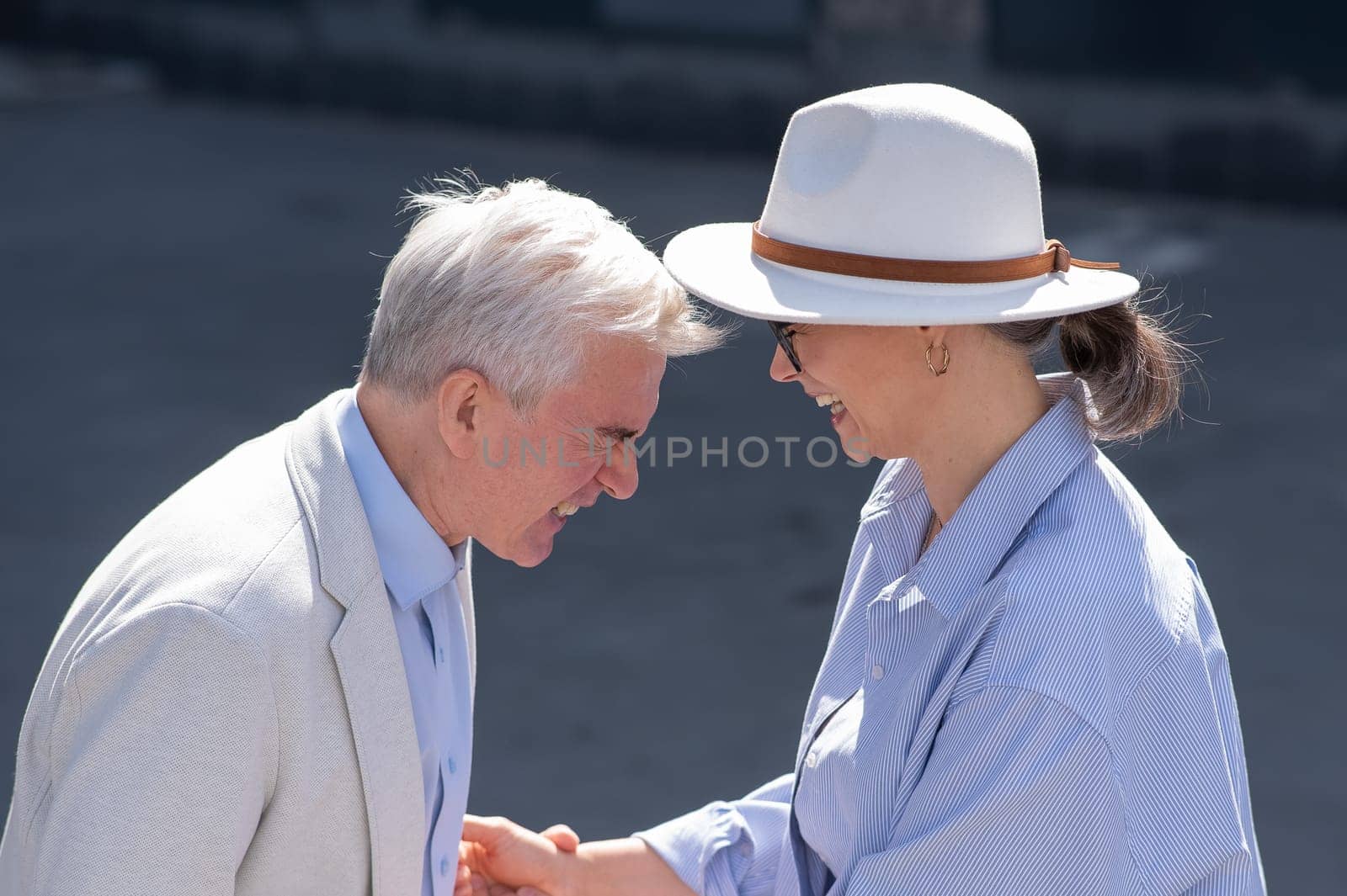 Stylish elderly laughing couple on a walk. Romantic relationships of mature people. by mrwed54