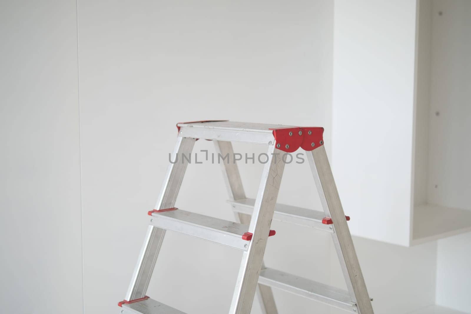 Metal ladder standing in empty room, renovation and improvement concept