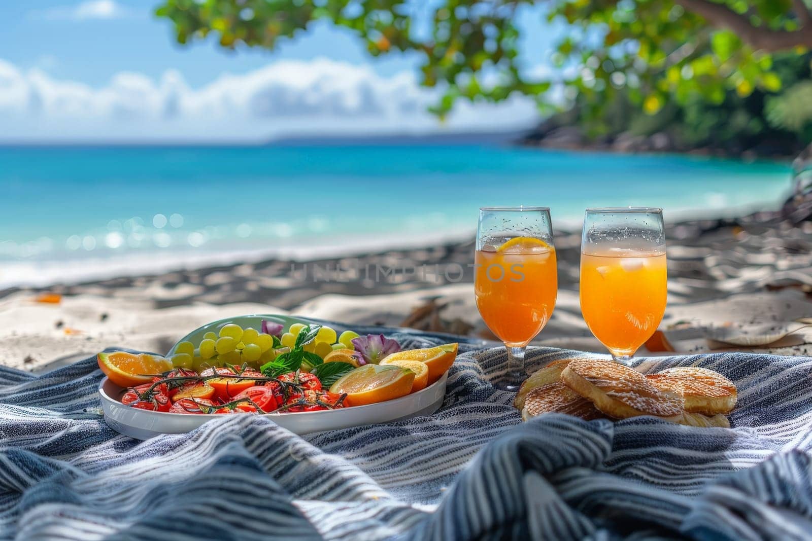 A picnic scene with food and glass of orange juice drink on picnic blanket at beach.