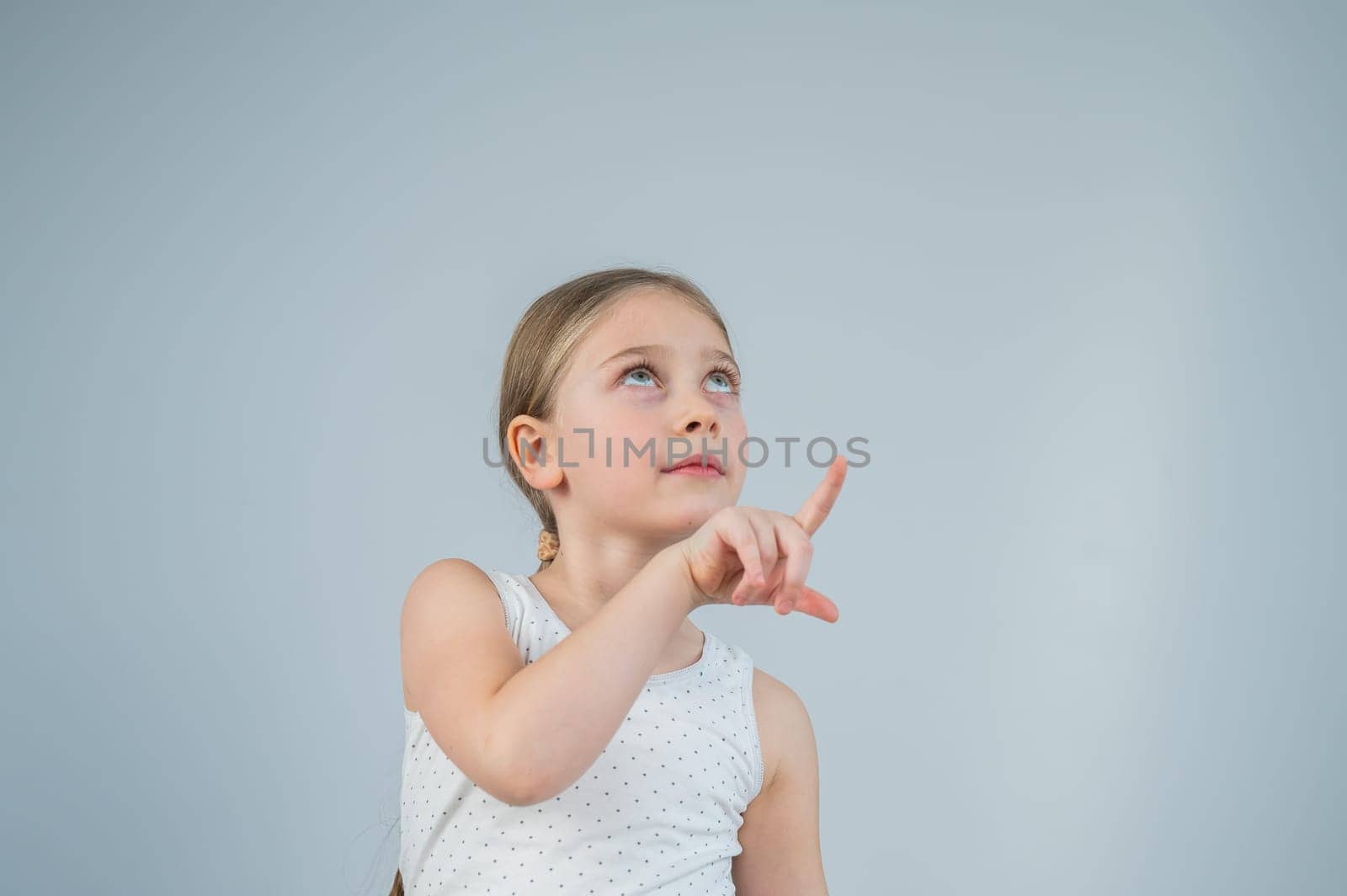Little Caucasian girl having fun and pointing with fingers on white background. by mrwed54