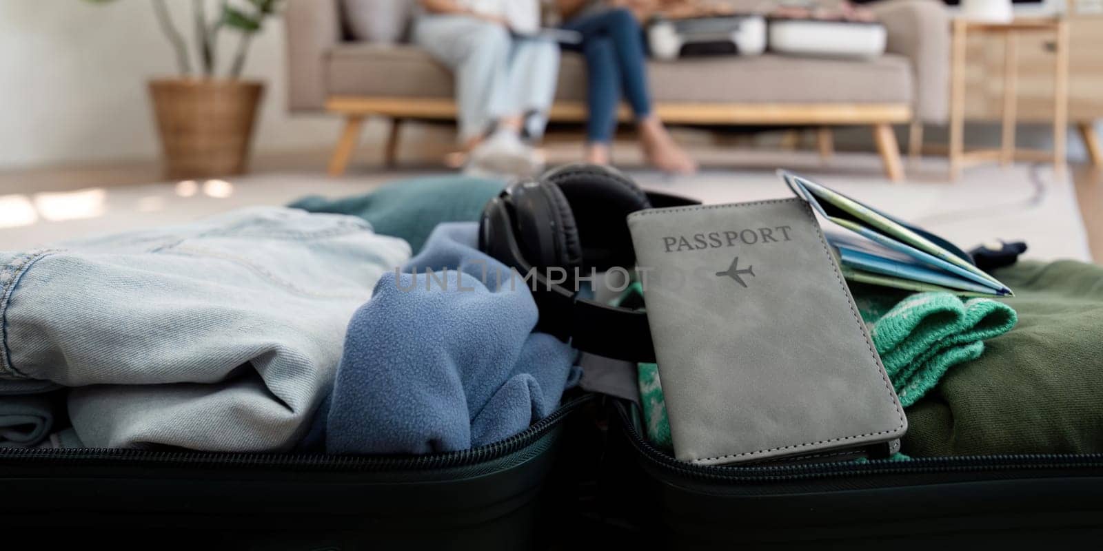 Friends and travel. Two asian young woman friends packing a travel bag before going on holidays by nateemee