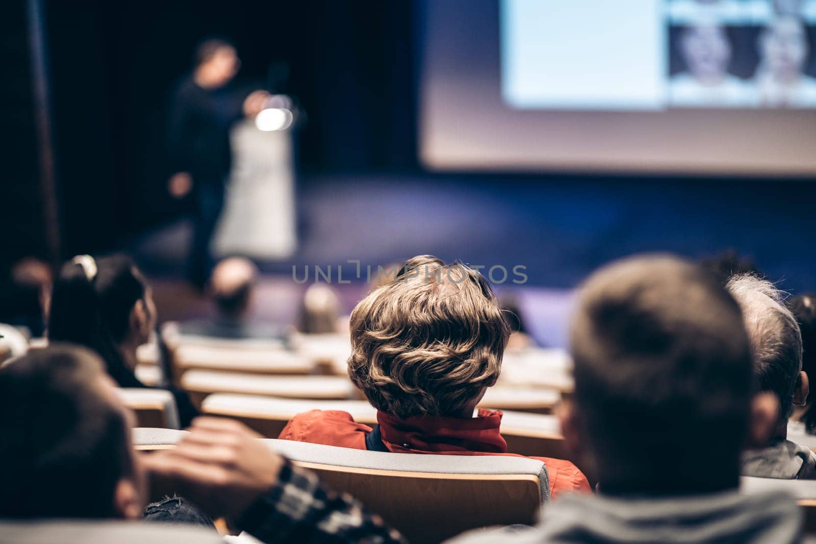 Speaker giving a talk in conference hall at business event. Rear view of unrecognizable people in audience at the conference hall. Business and entrepreneurship concept. by kasto