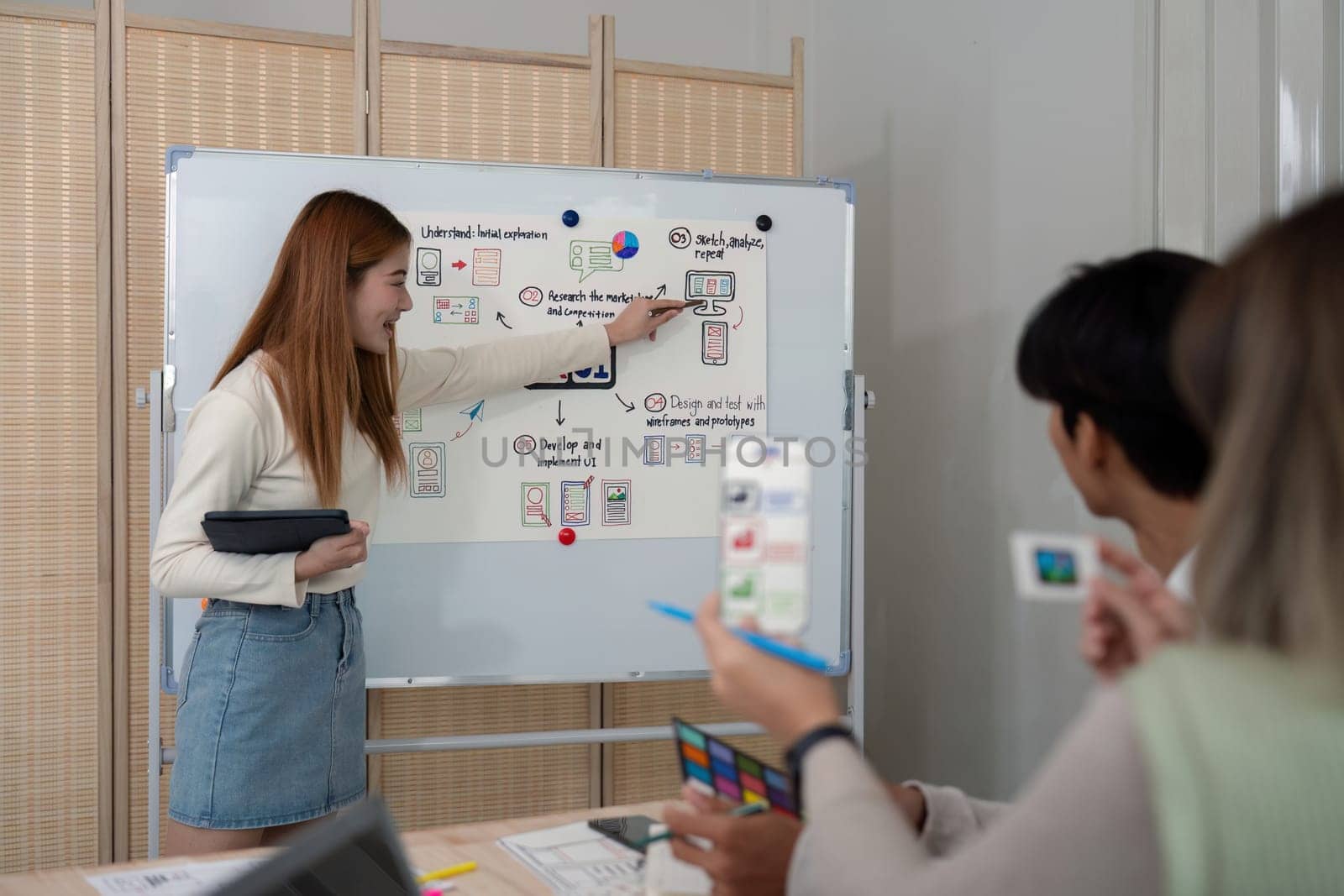 ux developer and ui designer presenting mobile app interface design on whiteboard in meeting at office. Creative digital development mobile app agency. digital transformation by nateemee