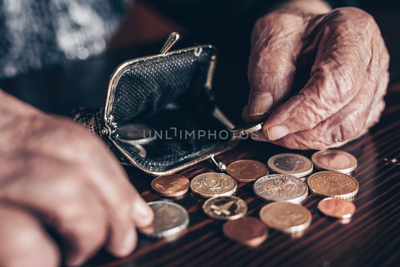 Detailed closeup photo of elderly 96 years old womans hands counting remaining coins from pension in her wallet after paying bills. Unsustainability of social transfers and pension system. by kasto