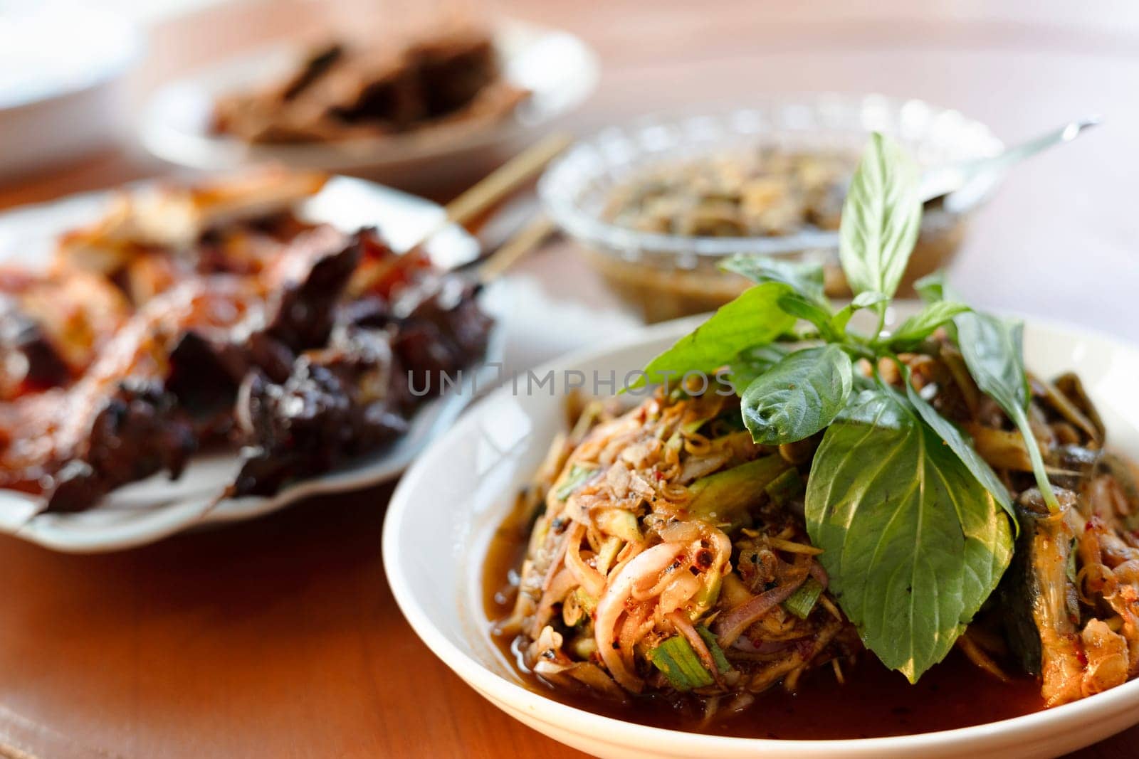 Local Thai food for people in the central region of Thailand. Spicy frog salad with vegetables and herbs. grilled chicken.
