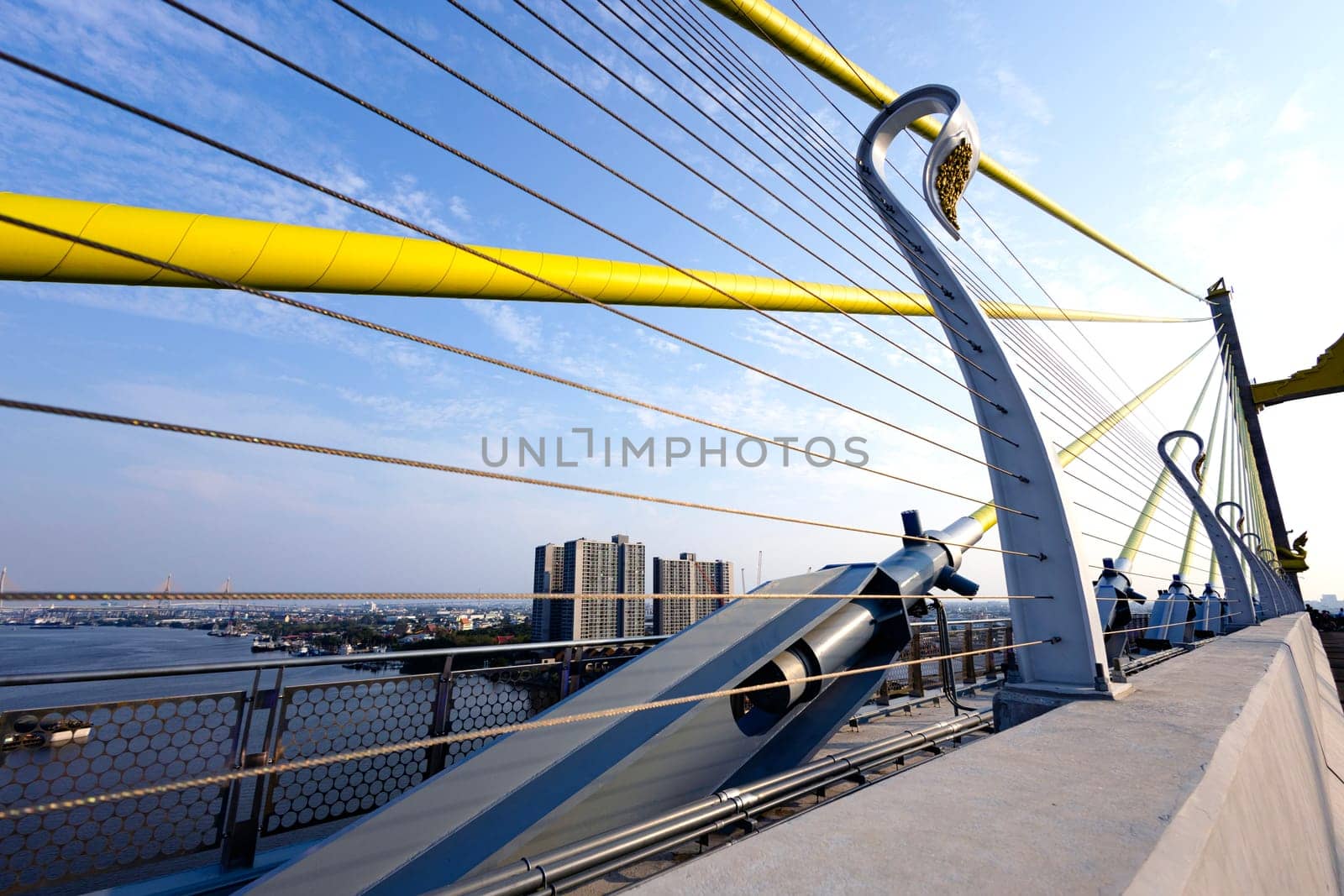 Yellow Cables On A Suspension Bridge Against Blue Sky In Bangkok by urzine