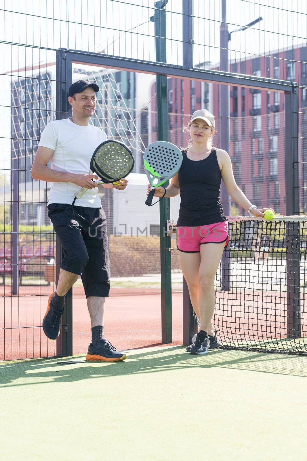 Young sporty woman and man playing padel together on same team by Andelov13