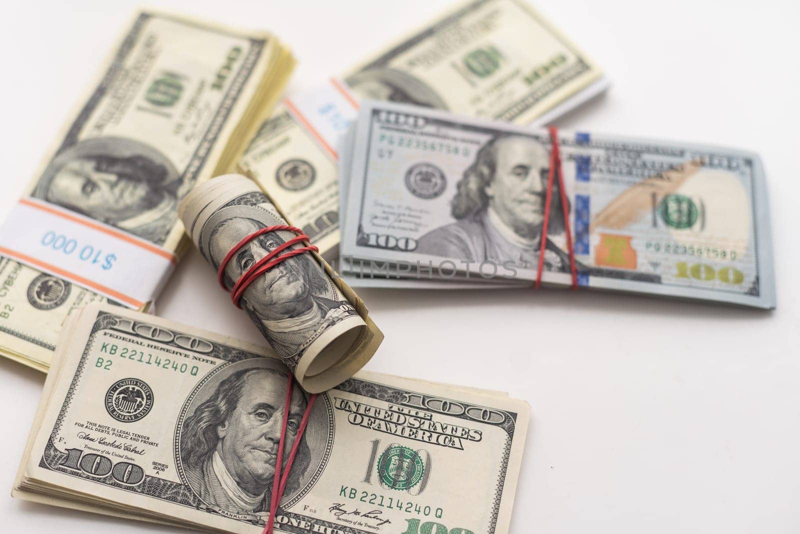 A bankroll of 100 bills on top of a pile of cash. High quality photo