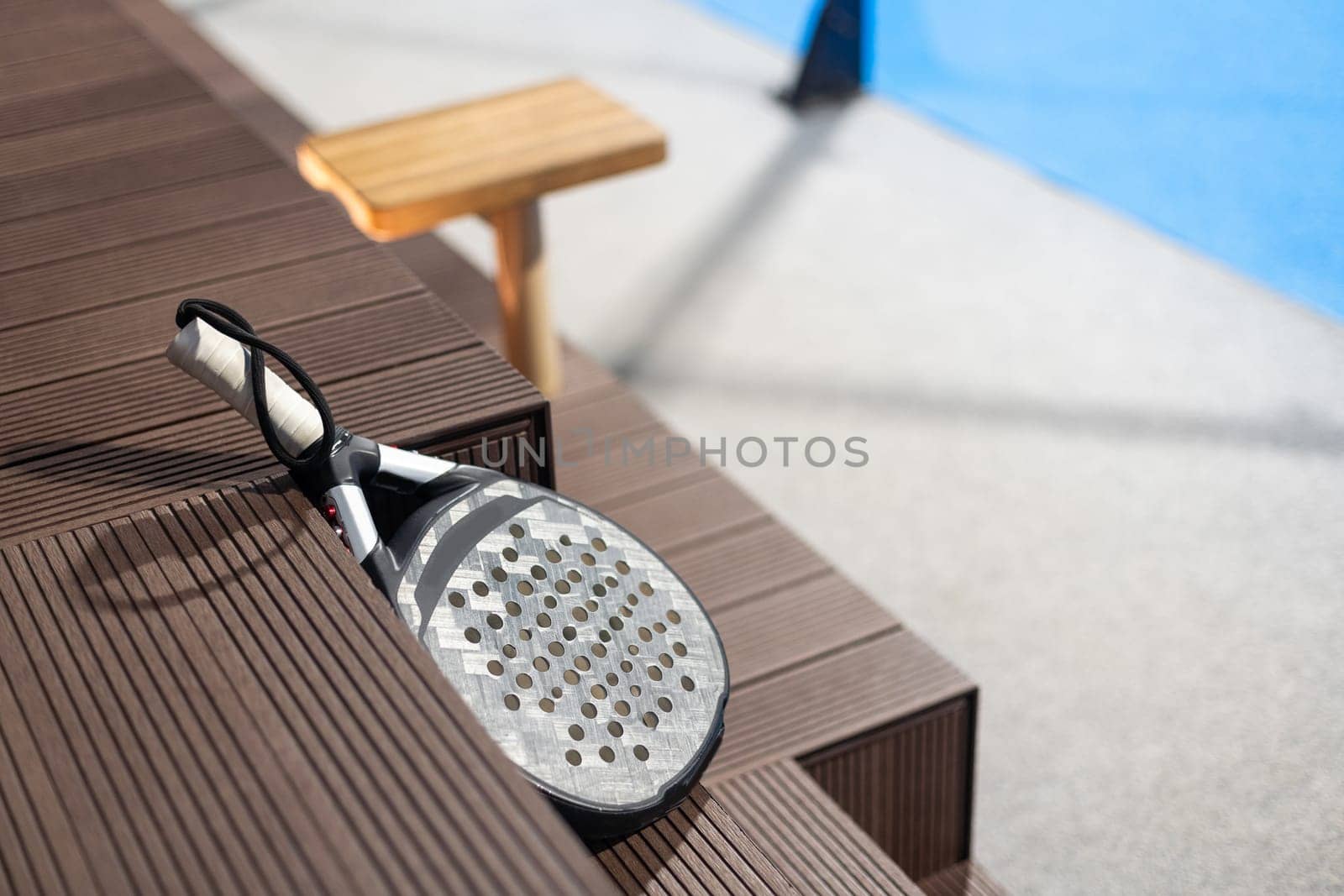 Paddle tennis: Paddel racket and ball in front of an outdoor court. High quality photo