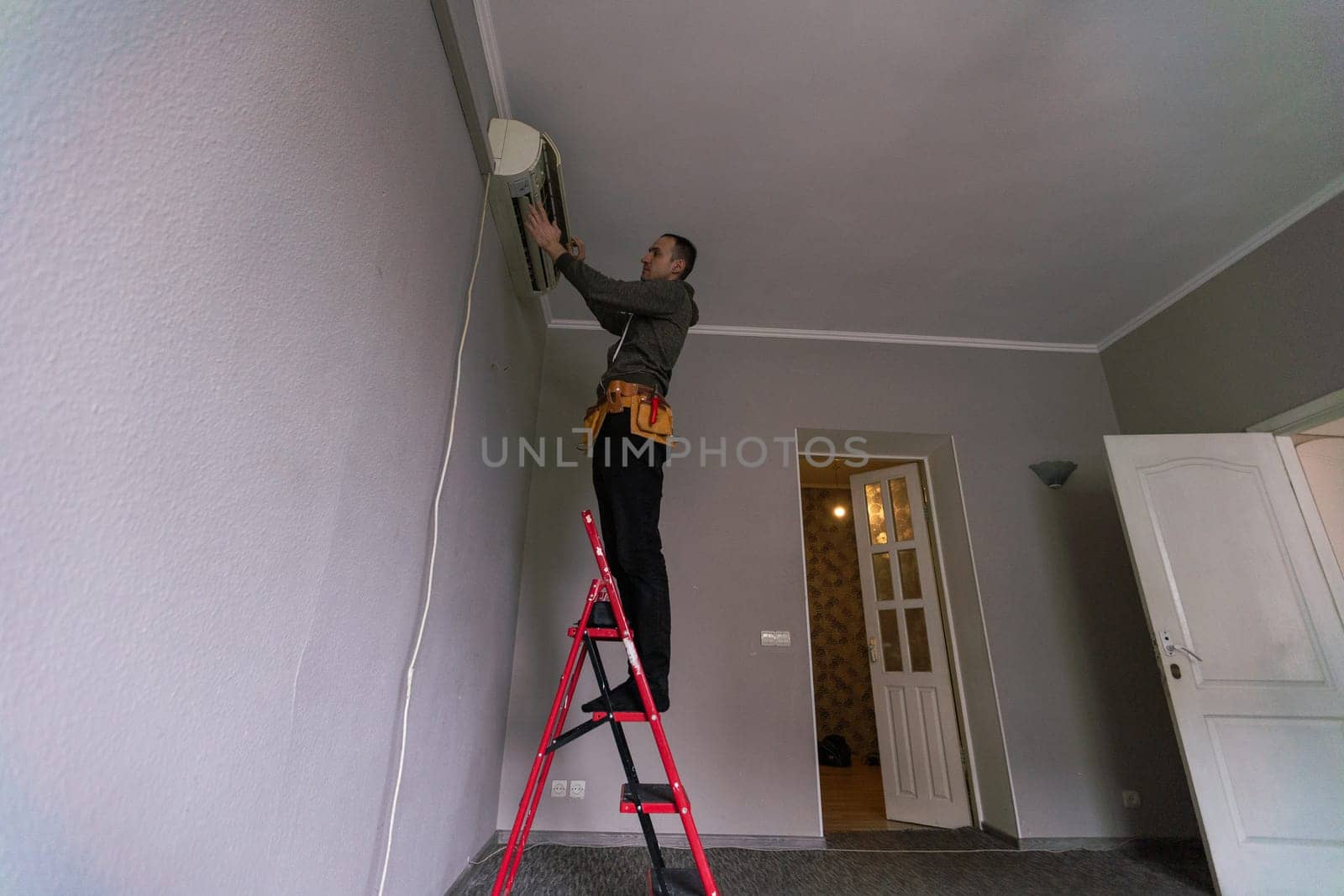 Male technician cleaning air conditioner indoors. High quality photo