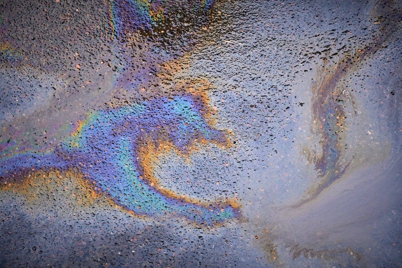 Oil rainbow gasoline spill on asphalt. Rainbow stains of oil and gasoline